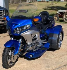 a blue motorcycle parked on top of a parking lot