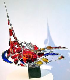 a colorful glass sculpture sitting on top of a white table