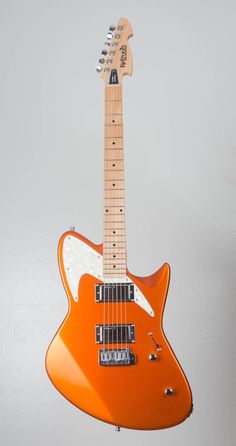 an orange electric guitar hanging from the ceiling