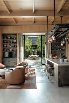 a living room filled with furniture next to a kitchen and dining room table in front of a sliding glass door