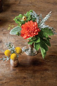 two vases filled with flowers on top of a wooden table