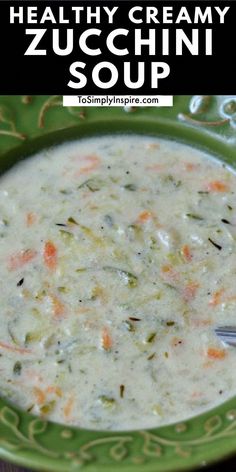 a bowl of creamy zucchini soup on a green plate with a spoon in it