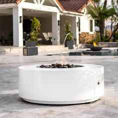 a white fire pit sitting on top of a patio