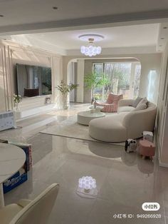 a living room filled with white furniture and lots of mirrors on the wall above it