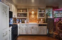 an ornate kitchen with white cabinets and wood floors is pictured in this image from the front view