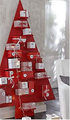 a red christmas tree with presents wrapped in white and brown paper on it's sides