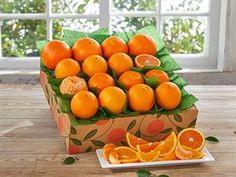 a box filled with oranges sitting on top of a wooden table