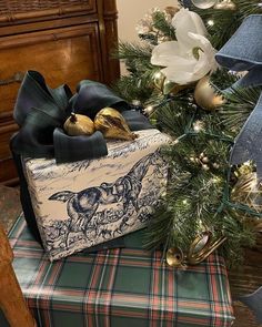 a wrapped present sitting on top of a table next to a christmas tree with decorations