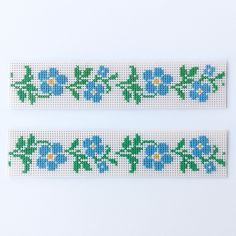 two pieces of cross stitch with blue flowers on them