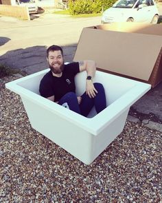 a man sitting in a white box on the ground