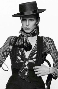 black and white photograph of a woman wearing a top hat, bow tie and suspenders