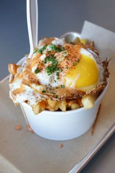 an egg is in a bowl with french fries