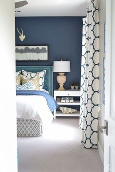 a bedroom with blue walls and white furniture