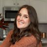 a woman standing in a kitchen smiling at the camera