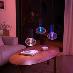 a living room filled with furniture next to a glass vase on top of a wooden table