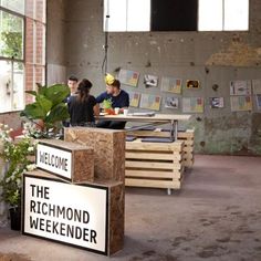 two people are sitting at a table in an abandoned building with signs on the walls