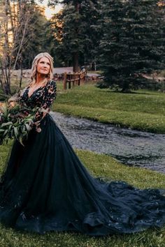 a woman in a long black dress holding flowers