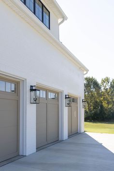 two garage doors are open in front of a white building