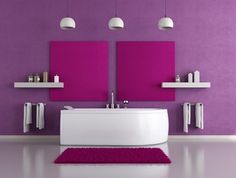 a white bath tub sitting under two purple wall hangings next to a sink in a bathroom