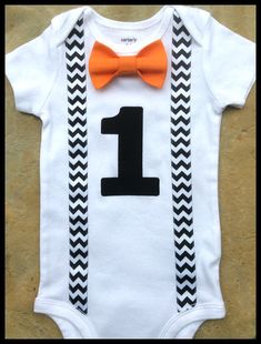 a baby bodysuit with an orange bow tie