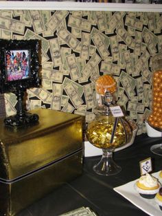 a table topped with lots of desserts and candies next to a wallpapered wall