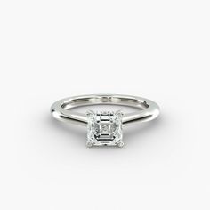 an engagement ring with a square cut diamond in the center, on a white background