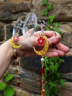 Transport yourself to an Autumn magical forest with this enchanting glasses chain inspired by nature's beauty.  Adorned with a golden crescent moon and a red flower charms, teardrop, oval and round beads in white, orange and red color palette, this piece captures the essence of femininity and elegance.  This eyeglass chain might be slightly heavier than regular chains because of some stone beads and crystals. Actual colors of any item or chains may slightly differ from screen to screen due to th Handmade Metal Glasses Chains As Gift, Handmade Elegant Glasses Chains For Festivals, Elegant Handmade Glasses Chains For Festivals, Elegant Handmade Festival Glasses Chains, Glasses Chain Aesthetic, Fantasy Glasses, Eyeglasses Chains, Beaded Glasses Chain, Yeri Mua