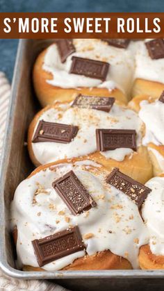 a pan filled with rolls covered in marshmallows and topped with white frosting