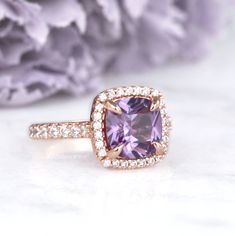 Gorgeous Classic Cushion Cut Ceylon Purple Sapphire Ring ►Base Metal: Sterling Silver (925) ►Plating: 14K Rose Gold ►Accented with simulated diamonds (CZ) ►Average band width: 1.9 mm Center Stone: Sapphire Color: Purple Gemstone Creation: 100% Genuine Lab-Grown Sapphire Stone Cut: Cushion Size: 8.0 x 8.0 mm Carat Weight: 2.5 ct. (approx.) Hardness: 9 (Mohs scale) ►Please be aware that plated jewelry can wear off over time, if this is a concern we would suggest going with the sterling silver or s Rose Gold Amethyst Ring With Accent Stones For Anniversary, Classic Rose Gold Birthstone Ring, Anniversary Rose Gold Amethyst Ring With Accent Stones, Elegant Birthstone Halo Ring For Anniversary, Elegant Anniversary Halo Ring With Birthstone, Elegant Amethyst Ring With Halo Design For Anniversary, Rose Gold Amethyst Ring With Halo Setting For Anniversary, Elegant Amethyst Halo Ring For Anniversary, Rose Gold Halo Setting Ring As A Gift