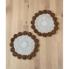 two brown and white crocheted doily on wooden floor