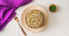 a bowl filled with rice next to a fork