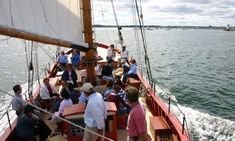 people are sitting on the deck of a boat