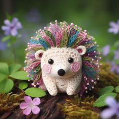 a small toy hedge sitting on top of a tree stump surrounded by flowers and greenery