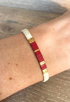 a red and white bracelet on someone's arm