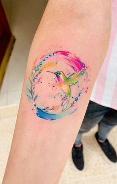 a colorful bird tattoo on the arm