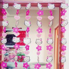 a mirror with hello kitty decorations hanging from it's sides and pink flowers on the side