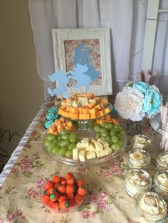 a table topped with lots of food next to a white framed picture on top of a wall