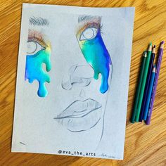 a drawing of a woman's face with blue and green paint on it