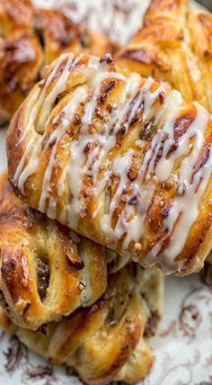 several pastry items on a plate with icing drizzled over them and sitting next to each other