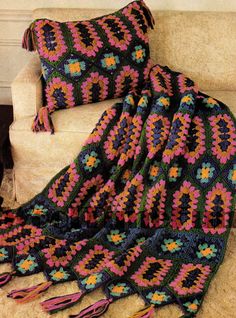 a crocheted blanket sitting on top of a couch