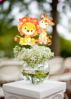 a vase filled with baby's breath flowers and two giraffes