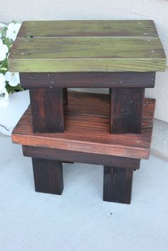 a small wooden bench sitting on top of a cement floor next to a flower pot