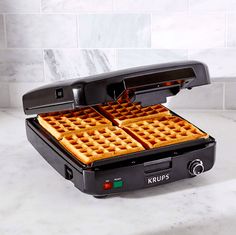 two waffles are being cooked in a griddle on a marble countertop