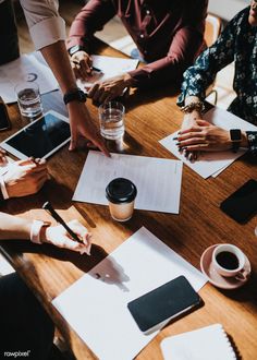 people sitting around a table with papers and pens