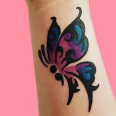 a colorful butterfly tattoo on the wrist