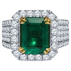 This modern cocktail ring features a GIA certified 3.86 carat octagonal cut emerald set in 18 karat yellow gold. It is accented by 2.32 carat total weight in round diamonds set in 18 karat white gold. The shank is very unique as it features diamonds that are continuous under the emerald. This ring is a size 7 but can be resized upon request. This emerald has been enhanced. Measurements: Emerald measures 11.24 x 7.97 x 5.14 mm Report: GIA 2225652140 Modern Cocktail, Emerald Set, Round Diamond Setting, Diamond Cocktail Ring, Diamond Cocktail Rings, Emerald Diamond, Heel Boots, Cocktail Ring, Cocktail Rings