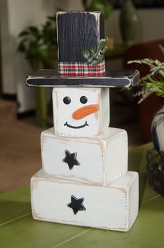 a snowman made out of wooden blocks sitting on top of a table