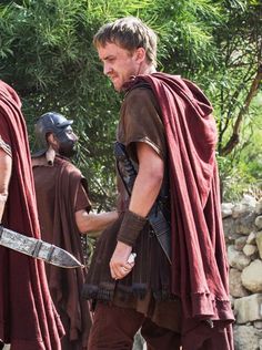 two men dressed in roman clothing holding swords