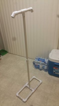 there is a white pole on the floor next to a cooler and some water bottles