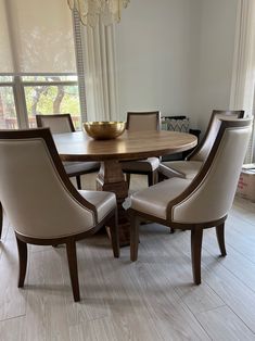 a dining room table with chairs around it and a bowl on the top of the table